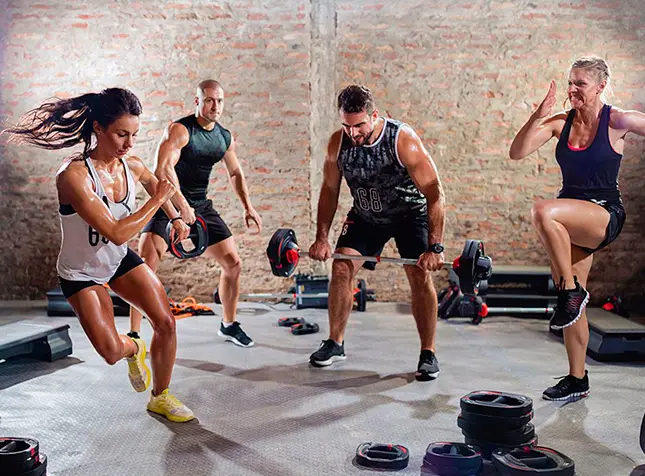 Turma de várias idades fazendo uma aula de treino funcional